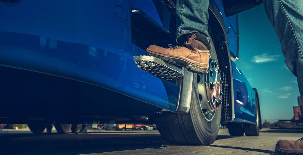 Truck Driver Getting Into the Semi. Legs Closeup.